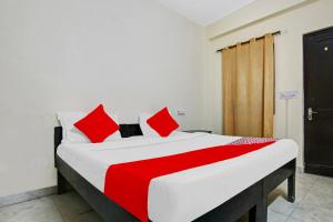 a bedroom with a large bed with red pillows at OYO Flagship Hotel B K Palace in New Delhi