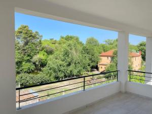 a balcony with a view of trees and a house at Ron Guesthouse 1 in Lezhë