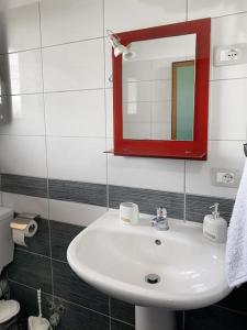 a bathroom with a white sink and a mirror at Ron Guesthouse 1 in Lezhë +8 photos