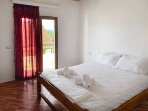 a bedroom with a white bed with towels on it at Ron Guesthouse 1 in Lezhë