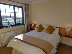 een slaapkamer met een bed en een groot raam bij Sea View Cottage, Errislannan in Ballyconneely