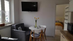 un soggiorno con un piccolo tavolo bianco e sedie di Pokoje goscinne, apartamenty Jas i Malgosia a Karwia