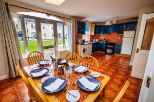 a kitchen with a wooden table with chairs and a dining room at 15 Killarney Holiday Village in Killarney