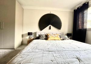 ein Schlafzimmer mit einem großen Bett und einem großen Ventilator an der Wand in der Unterkunft T2 Le SunScène-Parking-Clim-Terrasses-Centre- CapitalChic Services in Cannes