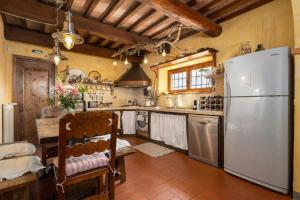 a large kitchen with a refrigerator and a table at Casa al Poggio and Chianti view in San Donato in Poggio