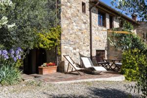 a patio with two chairs and a table in front of a building at Casa al Poggio and Chianti view in San Donato in Poggio