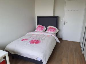 ein Schlafzimmer mit einem Bett mit rosa Blumen drauf in der Unterkunft Appartement 4 chambres 2 douches in Cergy