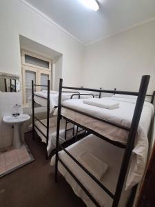 a room with three bunk beds and a sink at Residencial Ideal in Lisbon