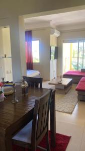 a dining room and living room with a wooden table at Résidence du golf in Fès