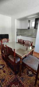 a dining room with a glass table and two chairs at Home Nikolić in Novi Pazar