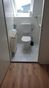 een kleine badkamer met een toilet en een raam bij Giraffe-1-4-Personen in Brunsbüttel