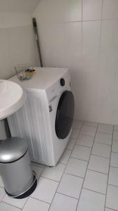 een wasmachine in een badkamer met een toilet bij Giraffe-1-4-Personen in Brunsbüttel