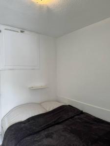 una piccola stanza bianca con un letto dentro di Confortable studio, wifi, parking, proche plage a Carnac