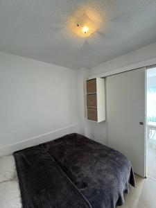 una camera da letto con un letto e un armadio al suo interno di Confortable studio, wifi, parking, proche plage a Carnac