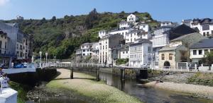 un puente sobre un río en una ciudad con edificios en La Casina de Luarca, en Luarca