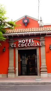 um edifício vermelho com um sinal de hotel Golisani em Hotel Escorial em La Serena