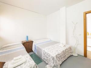a white room with two beds and a mirror at Cubo's Casa Rural Daza in Almogía