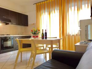 a kitchen with a table and yellow chairs in a kitchen at Settimo cielo in Rosolina Mare