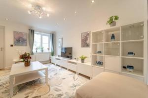 ein Wohnzimmer mit weißen Regalen und einem Tisch in der Unterkunft Stylish 3 Bed, 3 Bath, Garden & Drive for 2 cars in Colne