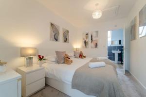 Un dormitorio blanco con una cama con dos ositos de peluche. en Stylish 3 Bed, 3 Bath, Garden & Drive for 2 cars en Colne