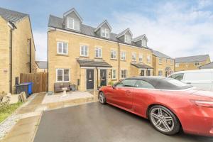 un coche rojo estacionado frente a una casa en Stylish 3 Bed, 3 Bath, Garden & Drive for 2 cars en Colne