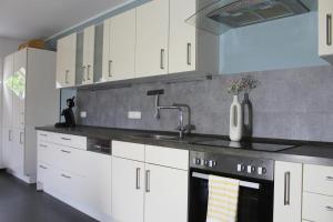 a kitchen with white cabinets and a sink at Ferienwohnung Woidblick in Drachselsried