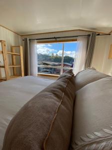 a bedroom with a large bed with a large window at Refugio Ballena Hostel in Castro