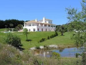 a large house on a hill with a pond at Villa Martin in Óbidos