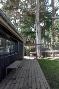 a wooden deck with a bench and a tree at PYLA: Nice creative studio 200 m from the beach in La Teste-de-Buch