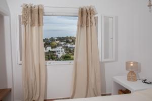 uma janela com cortinas num quarto branco em Melitini's House em Alinda