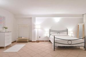 um quarto branco com uma cama e um espelho em La dolce vita Barisardo em Bari Sardo
