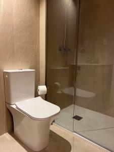 uma casa de banho com um WC e uma cabina de duche em vidro. em Piscina con Glamour em Múrcia