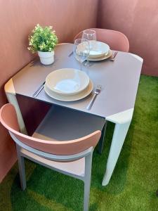 una mesa blanca con platos y copas de vino. en Piscina con Glamour, en Murcia
