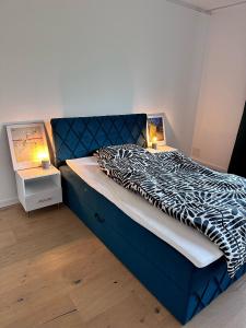 1 dormitorio con cama azul y edredón blanco y negro en Modern Art Apartment Düsseldorf - 10 Min to Trade Fair & Stadium, en Düsseldorf