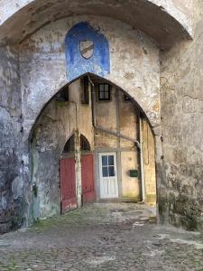 une arche dans un bâtiment en pierre avec une porte dans l'établissement La Tour, à Semur-en-Auxois