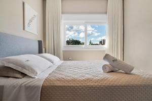 1 dormitorio con 1 cama y ventana en Apartamento Essence 2 Suítes by Achei Gramado, en Gramado