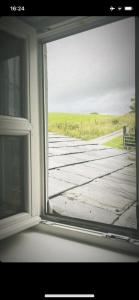 an open window with a view of a wooden bridge at Pringle cottage in Clones