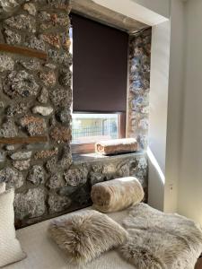 a room with a stone wall and a window at Olympus Stone Lodge in Litochoro