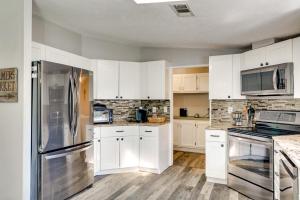 a kitchen with white cabinets and a stainless steel refrigerator at Family-Friendly Palm City Home 14 Mi to Beach! in Palm City