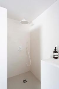 a white bathroom with a shower in the ceiling at PYLA: Nice creative studio 200 m from the beach in La Teste-de-Buch