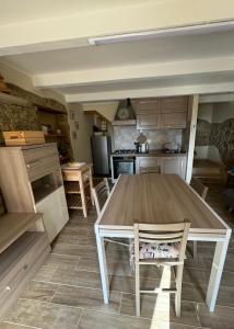una cocina con mesa de madera y sillas. en La Casa dei Nonni, en Sasso dʼOmbrone