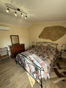 een slaapkamer met een bed en een houten vloer bij La Casa dei Nonni in Sasso dʼOmbrone