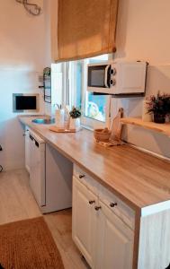 a kitchen with white cabinets and a wooden counter top at La Mata primera línea de playa in Torrevieja