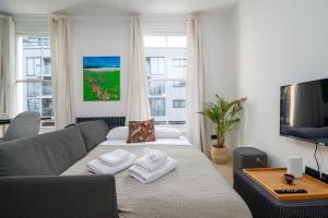 uma sala de estar com um sofá e uma televisão em GuestReady - Luxury Central London Apartment em Londres