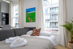 uma sala de estar com um sofá com toalhas em GuestReady - Luxury Central London Apartment em Londres