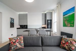 a living room with a couch and a kitchen at GuestReady - Luxury Central London Apartment in London