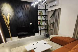 a living room with a couch and a tv at Rita's 2-BR Apt in Mar Mikhael in Beirut