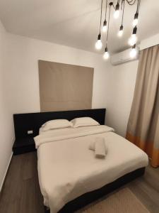 a bedroom with a large bed with white sheets at Rita's 2-BR Apt in Mar Mikhael in Beirut