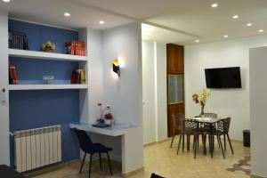 sala de estar con mesa, sillas y pared azul en Casa Grazia - Guest House -, en Reggio Calabria