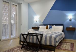1 dormitorio con 1 cama con pared azul en Casa Grazia - Guest House -, en Reggio Calabria